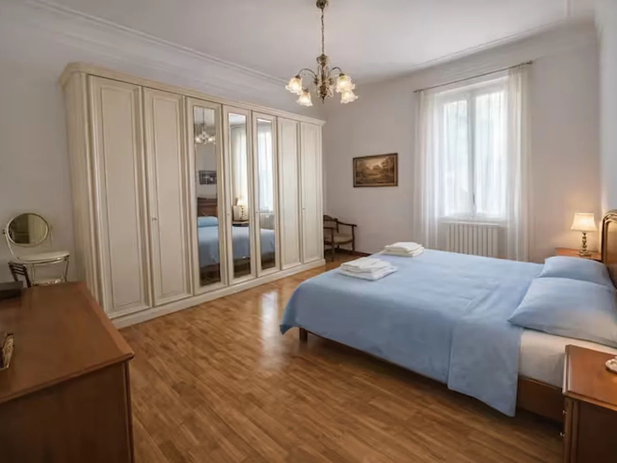 Main bedroom with blue bedding and large wardrobe.