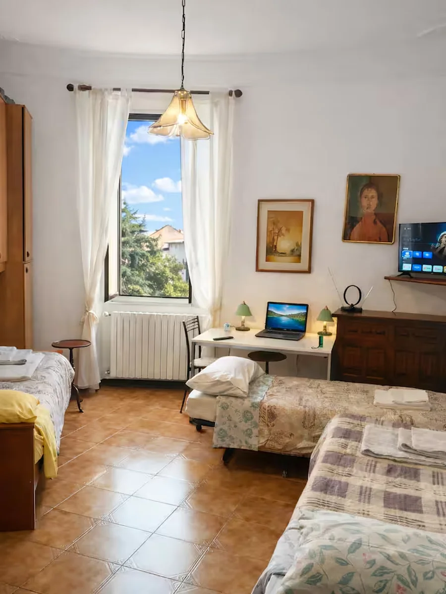 Large second sleeping area with multiple beds and tall window.