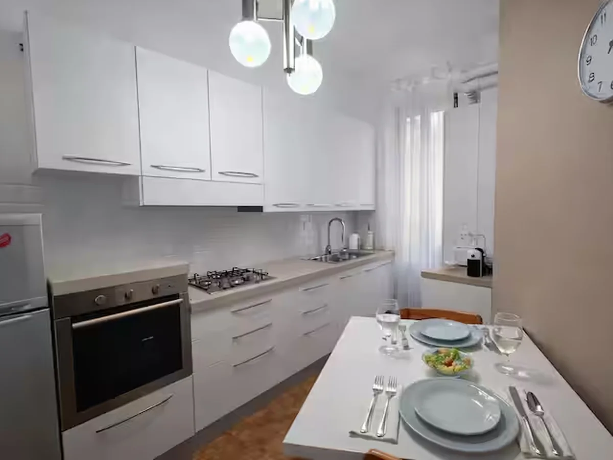 Clean white kitchen with dining table set for two.